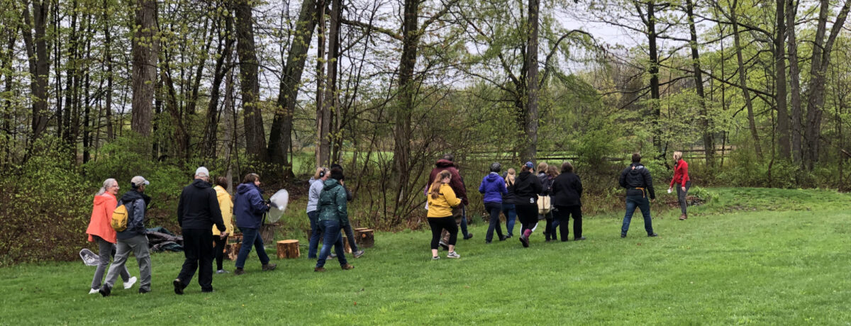 Photo of people walking at a nature center, carrying scientific equipment